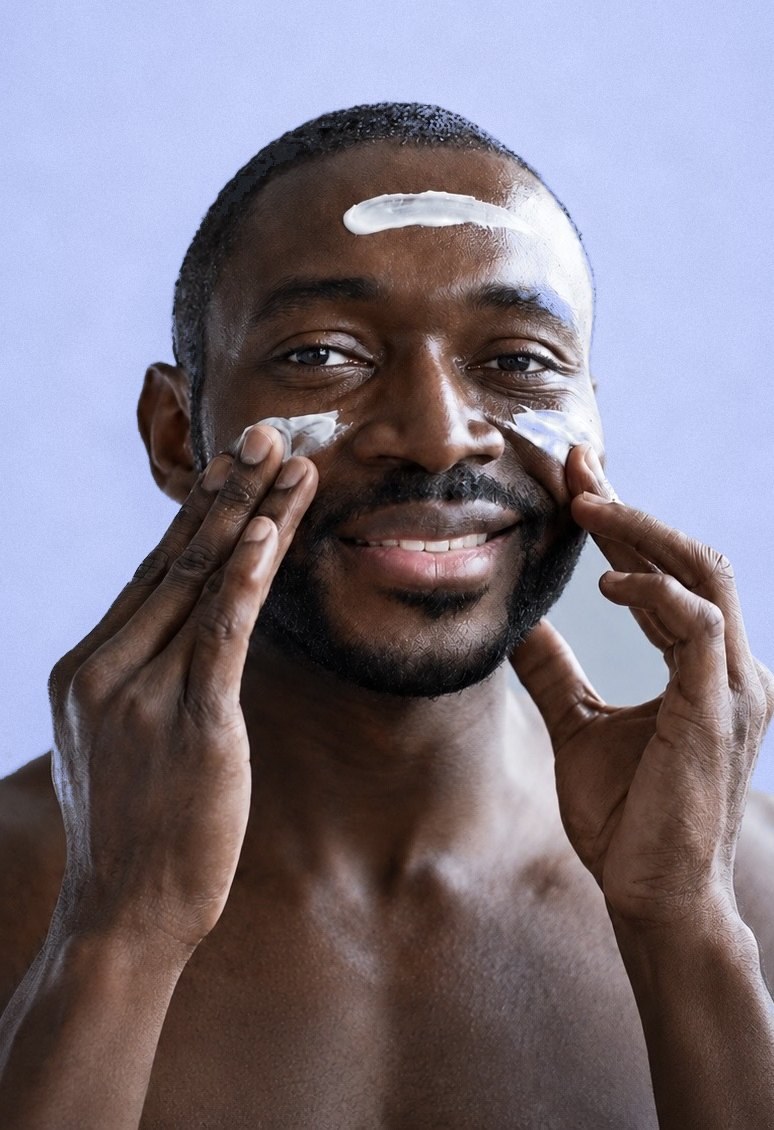 Black man applying white facial cream